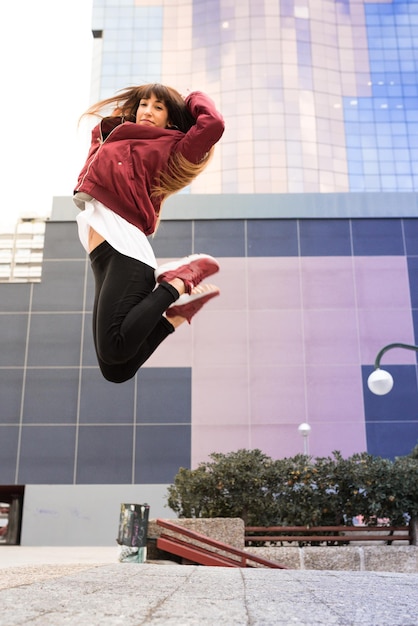 Heureuse jeune femme qui danse dans la rue xA