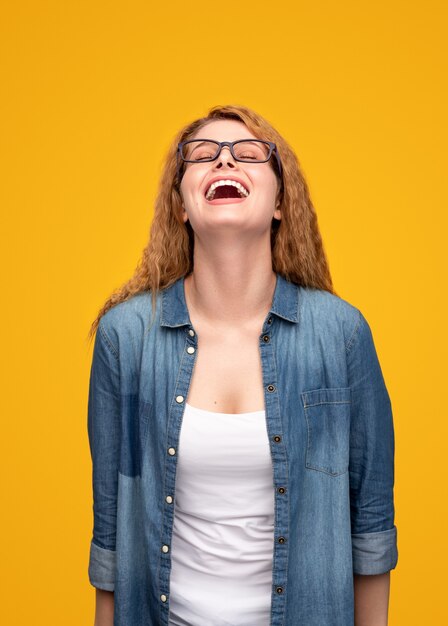 Heureuse jeune femme riant les yeux fermés