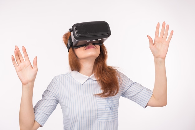 Heureuse jeune femme rousse à l'aide d'un casque de réalité virtuelle