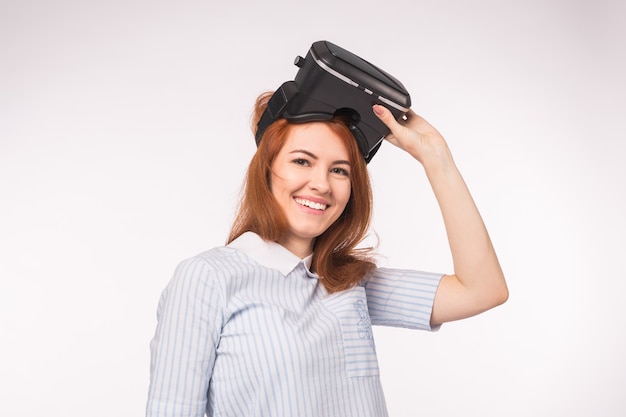 Photo heureuse jeune femme rousse à l'aide d'un casque de réalité virtuelle