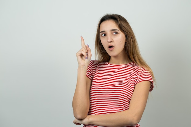 Heureuse jeune femme rousse caucasienne en chemise d'été regarde de côté avec une expression pensive envisage un plan d'action supplémentaire