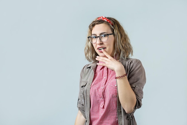 Heureuse jeune femme rousse caucasienne en chemise d'été regarde de côté avec une expression pensive envisage un plan d'action supplémentaire