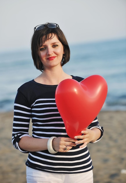 heureuse jeune femme se détendre sur la belle plage au frais matin d'été et profiter du premier rayon de soleil