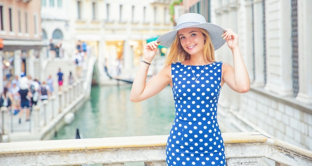 Heureuse jeune femme séduisante mannequin de Venise Italie en tenue à pois bleu.