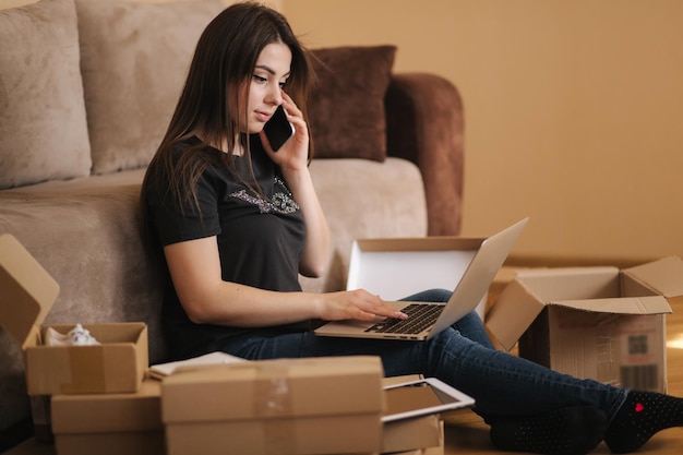 Heureuse jeune femme shopping en ligne femme utilise un ordinateur portable et une tablette pour rechercher de nouveaux produits attrayants