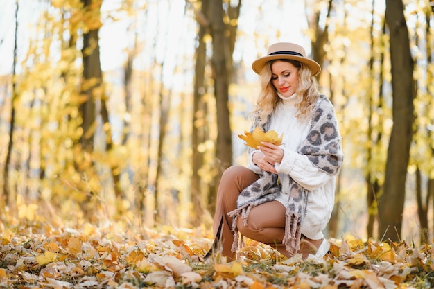 Heureuse jeune femme souriante dans le parc le jour de l'automne