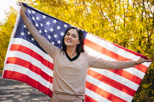 Heureuse jeune femme souriante avec drapeau américain