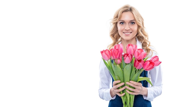 Heureuse jeune femme en tablier avec des fleurs de tulipes printanières isolées sur fond blanc