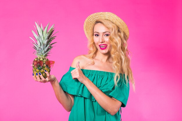 Photo heureuse jeune femme tenant un ananas