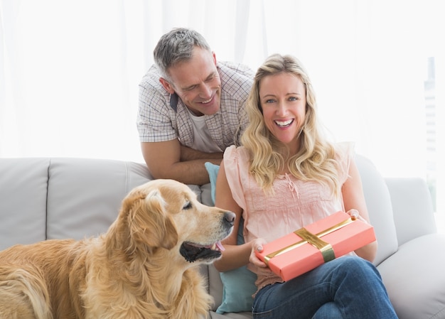 Heureuse jeune femme tenant son cadeau d&#39;anniversaire en face d&#39;elle