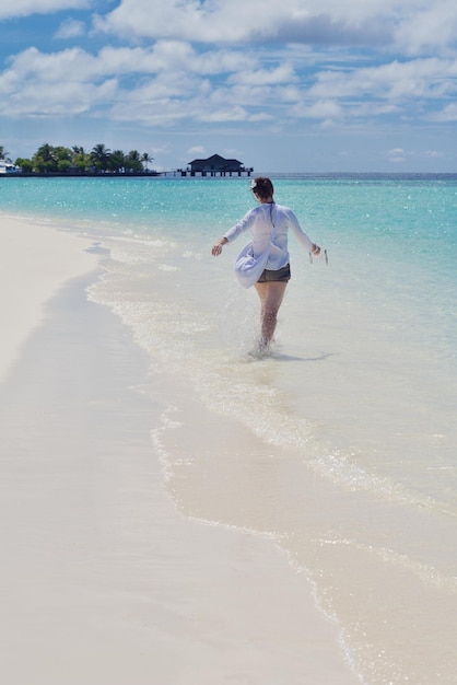 heureuse jeune femme en vacances d'été sur la belle plage tropicale s'amuser et se détendre