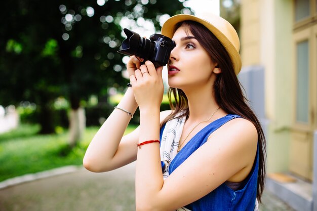 Heureuse jeune femme en vacances photographier avec appareil photo dans la rue de la ville