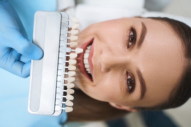 Heureuse jeune femme visite une clinique dentaire pour prendre soin des dents et obtenir un meilleur sourire