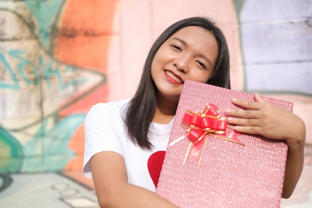 Heureuse jeune fille avec boîte-cadeau