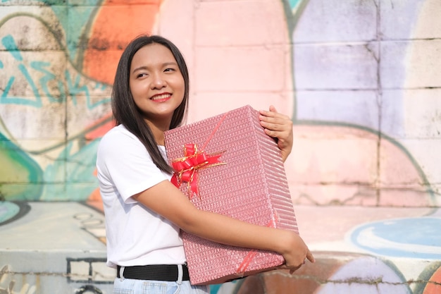 Heureuse jeune fille avec boîte-cadeau