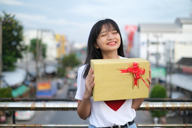 Heureuse jeune fille avec boîte-cadeau