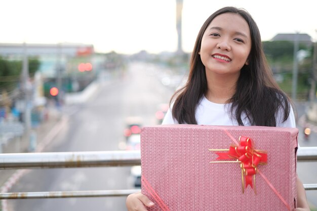 Heureuse jeune fille avec boîte-cadeau