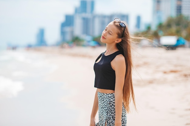 Heureuse jeune fille profite de vacances à la plage tropicale