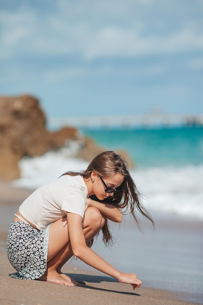 Heureuse jeune fille profite de vacances à la plage tropicale