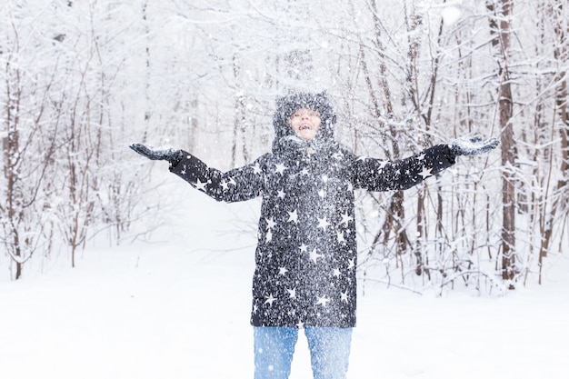 Photo heureuse jeune fille vomir une neige dans une forêt d'hiver