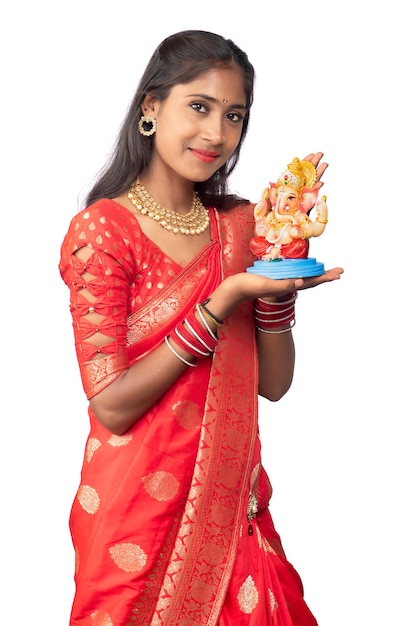 Heureuse jeune indienne posant avec la statue de Ganesha à l'occasion du festival de Ganesh