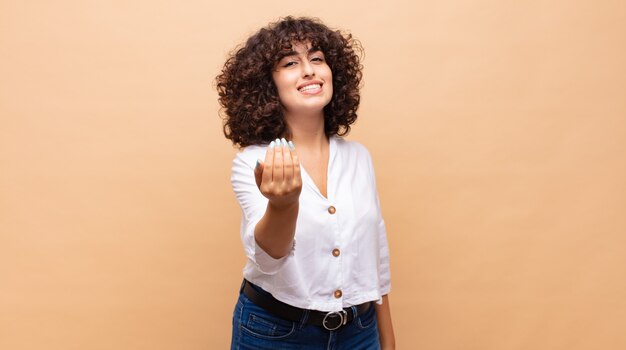 Heureuse jeune jolie femme aux cheveux bouclés