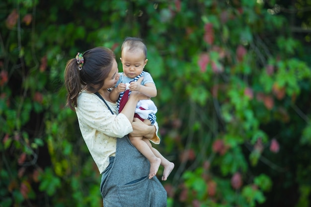 Heureuse jeune maman jouant et s&#39;amusant avec son petit fils