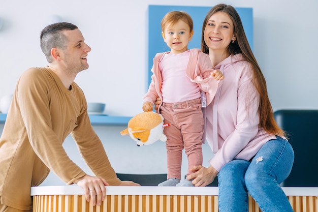 Heureuse jeune mère et père avec petite fille sont assis je