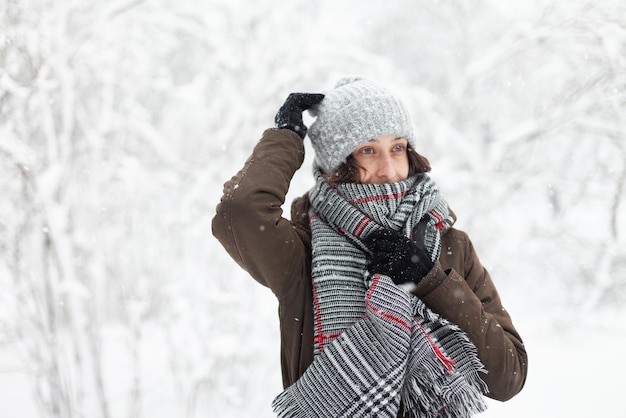 Heureuse jolie femme dans des vêtements chauds en hiver neigeux à l'extérieur