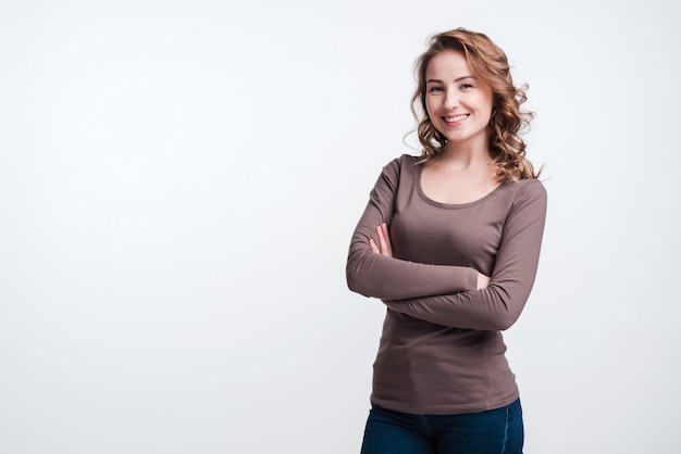 Heureuse jolie femme debout avec les mains jointes portant des vêtements décontractés