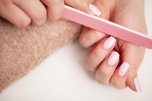 Heureuse jolie femme faisant une manucure en se reposant à la maison