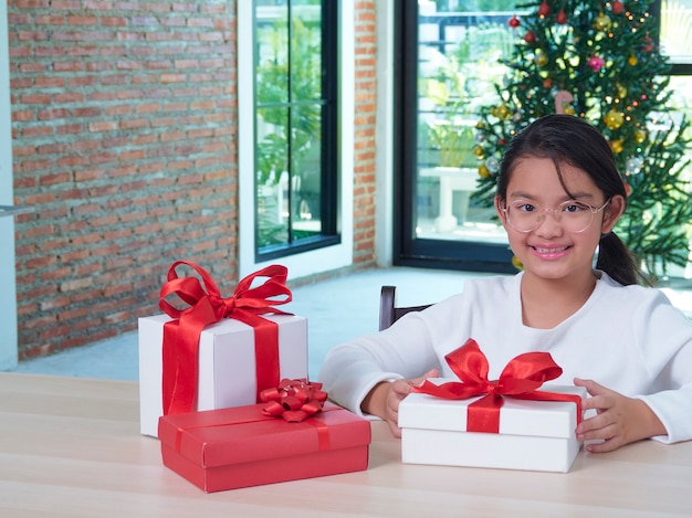 Heureuse jolie fille avec des coffrets cadeaux à la maison avec des décorations festives. Joyeux Noël heureuse nouvelle année.