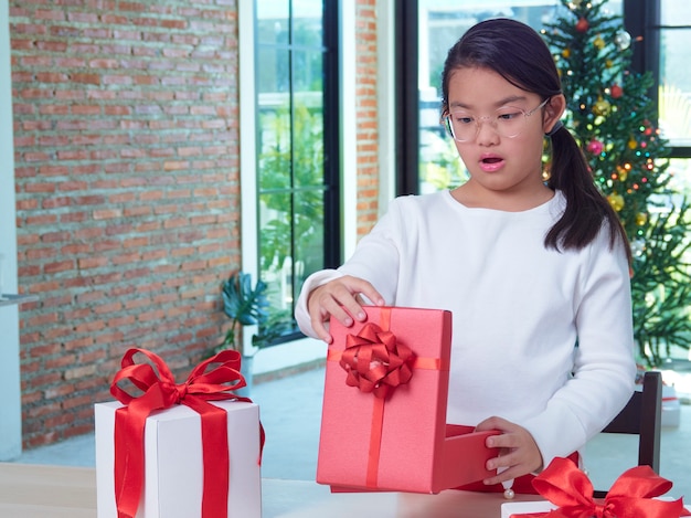 Heureuse jolie fille avec des coffrets cadeaux à la maison avec des décorations festives. Joyeux Noël heureuse nouvelle année.