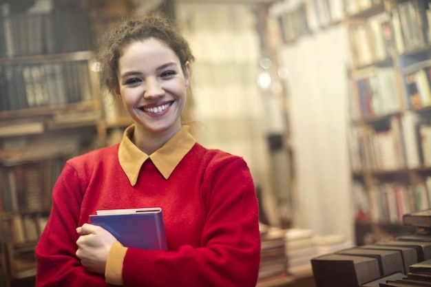 Heureuse jolie fille dans la bibliothèque