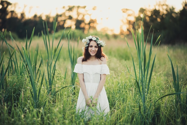 Heureuse jolie fille en robe blanche souriant joyeusement