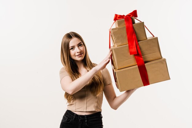 Heureuse jolie jeune femme tenant des coffrets cadeaux avec cadeau sur fond blanc Célébration de l'événement et réception d'un cadeau pour un anniversaire ou un autre jour férié