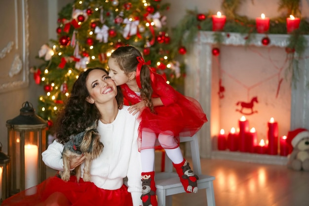 Heureuse maman fête Noël avec sa fille maman et sa fille sont vêtues de jupes rouges et le ...