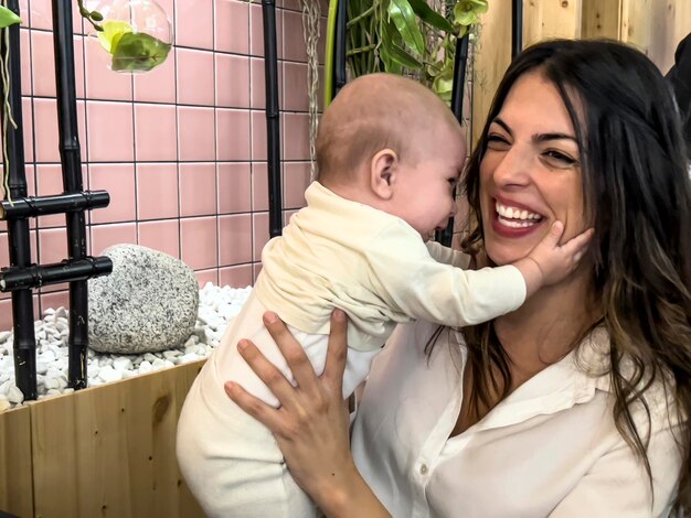 Photo heureuse maman jouant avec bébé