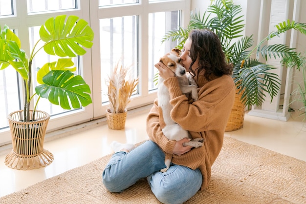 Heureuse maman et sa fille jouent avec leur adorable Jack Russell Terrier câblé