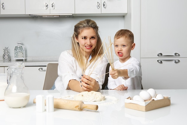 Heureuse maman et son fils mettent des guimauves sur un bâton