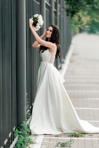 Heureuse mariée avec un bouquet de mariage dans une rue de la ville. événements et traditions