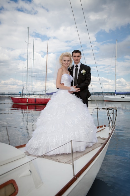 Heureuse mariée et le marié étreignant sur un yacht