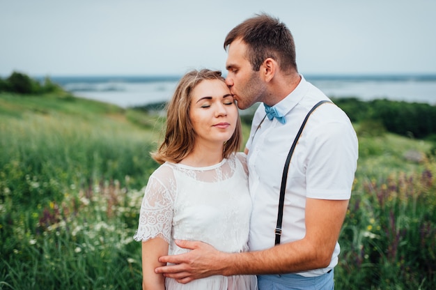 Heureuse mariée et le marié marchant sur l'herbe verte