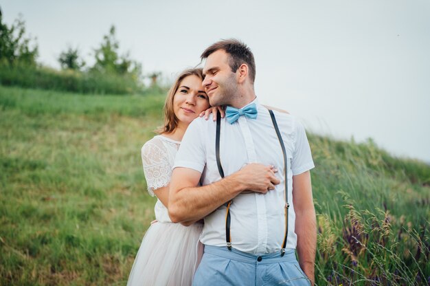 Heureuse mariée et le marié marchant sur l'herbe verte