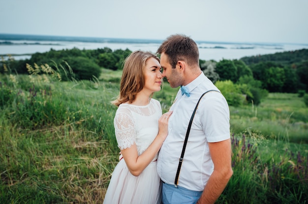 Heureuse mariée et le marié marchant sur l'herbe verte