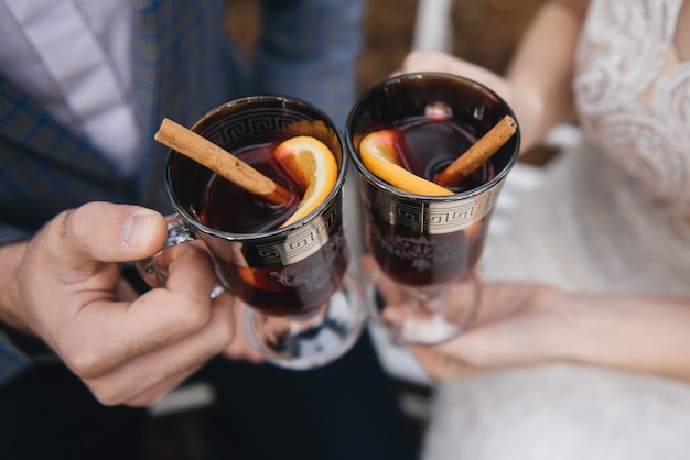 Heureuse mariée et le marié tenant des verres de vin chaud