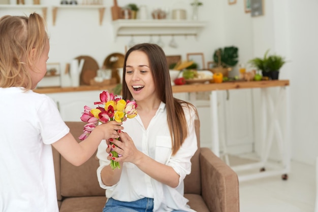 Heureuse mère accepte un cadeau de sa petite fille Félicitations pour l'anniversaire de la fête des mères ou la journée de la femme