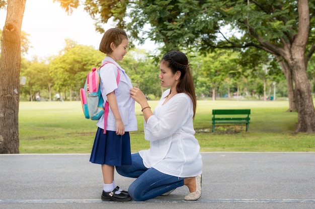 Heureuse mère asiatique avec l'élève des enfants à l'école.