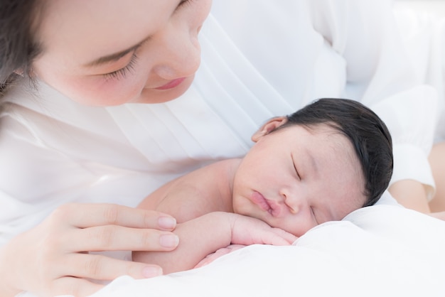 heureuse mère avec bébé au lit