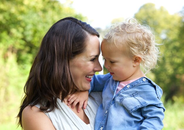 Heureuse mère et bébé souriant face à face